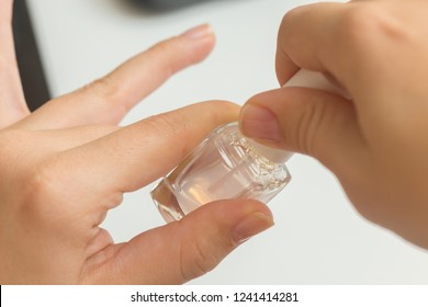 Putting Clear Varnish On Finger Nails On A White Background