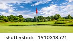 Putting green with a flag at a golf course on a summer day