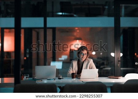 Putting her career first. a businesswoman using a laptop at her desk during a late night at work.