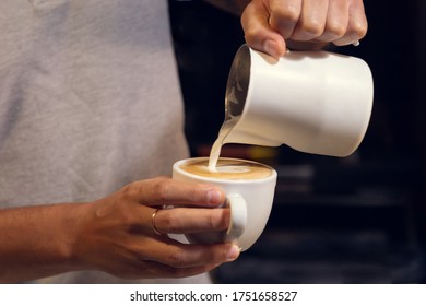 Putting milk with a jug in a cafe making a heart shape - Shutterstock ID 1751658527