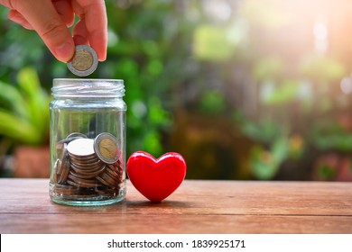 Putting Money Coin On Saving Glass Bottle For Concept Donation And Philanthropy