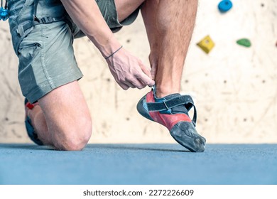 putting on climbing shoes next to the climbing wall - Powered by Shutterstock