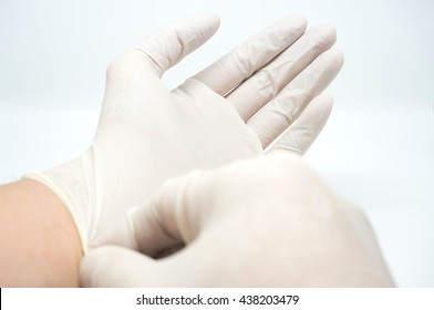 Putting On Disposable Sterile White Gloves On White Background