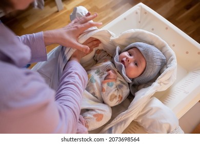 putting on warm clothes on baby girl preparing for a walk on cold winter day. - Shutterstock ID 2073698564