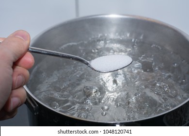 Putting Salt In Hot Boiling Water In Pan