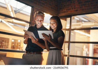 Putting their best productivity feet forward. Shot of two designers using their digital tablets while working nightshift. - Powered by Shutterstock