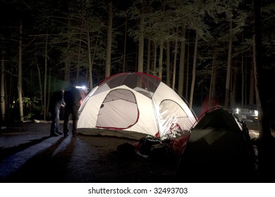 Putting Together Tent At Night On Camp Site