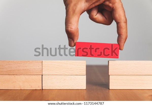 Putting a\
wooden block between gap, business\
concept