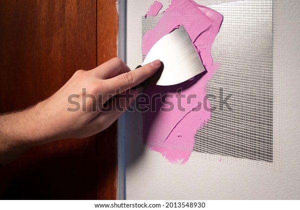 Putty knife application of spackling compound or\
damaged drywall patch