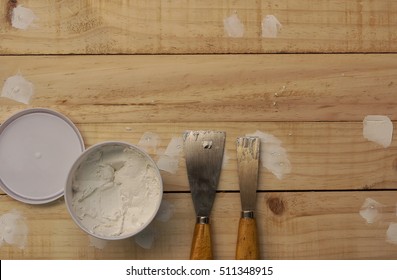 Putty knife and the wooden floor.