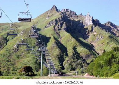 Puy De Sancy France Circa May 2019. Chair Lift With Cable Leading To The Top Of The Mountain. Green Slopes Jagged Summit. No People.