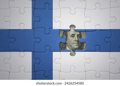 puzzle with the colourful national flag of finland and usa dollar banknote. finance concept