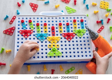 Puzzle Construction Toy With Electric Drill. Child Drills Colorful Screw Into The Board. Hanukkah Menorah. Craft For Kids.