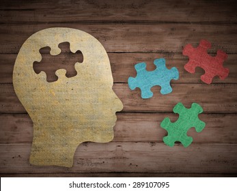 Puzzle head brain concept. Human head profile made from brown paper with a jigsaw piece cut out. Choose your personality that suit you