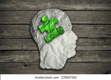 Puzzle Head Solution Concept As A Human Face Profile Made From Crumpled White Paper With A Jigsaw Piece Cut Out Inside The Brain Area On Old Wood Background. Mental Health Symbol. 