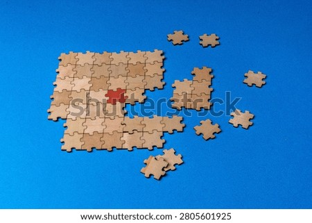 Puzzle pieces constructing solution with red highlight for strategy