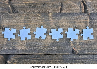 Puzzle Pieces On Wooden Table