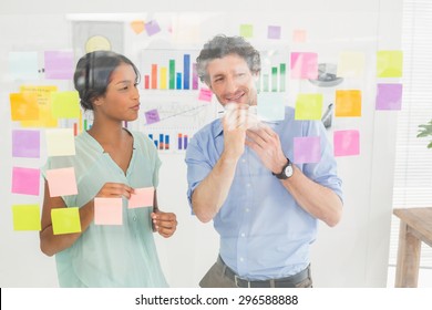 Puzzled Business Team Looking Post Its On The Wall In The Office