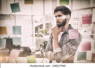 Puzzled Businessman Looking Post Its On The Wall In The Office