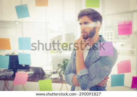 Puzzled businessman looking post its on the wall in the office