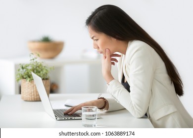 Puzzled Confused Asian Woman Thinking Hard Concerned About Online Problem Solution Looking At Laptop Screen, Worried Serious Korean Businesswoman Focused On Solving Difficult Work Computer Task