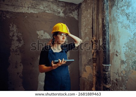 
Puzzled Engineer Holding a Pc Tablet on a Construction Site 
Stressed architect checking the blueprint for the project on her device