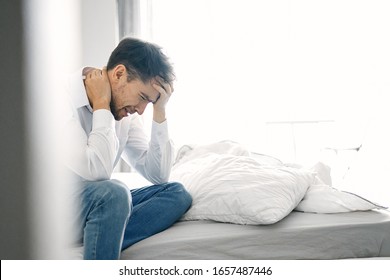 Puzzled look of a man on a bed indoors