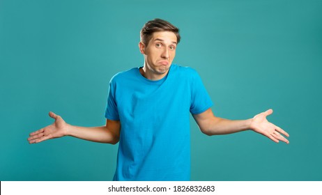Puzzled male portrait. Careless gesture. Helpless emotion. So what. Doubtful expressive man shrugging looking at camera isolated on blue.