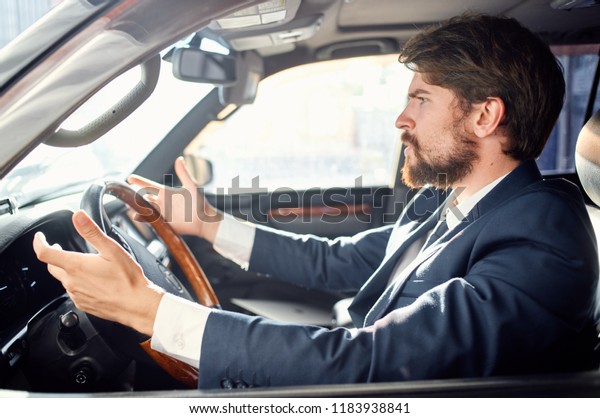 puzzled man sits behind the wheel of a car              \
           