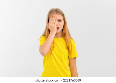 Puzzled Teen Girl Making Facepalm, Looks Amazed Open Mouth And Covers Half Of Face With Palm, Seriously Looks With One Eye At Camera, Stands Over White Studio Background