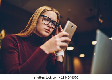 Puzzled Woman In Spectacles For Provide Eyes Protection Reading Bad News About Internet Connection Via Text Message From Operator On Cellular Phone, Hipster Girl Dialing Number And Feeling Headache