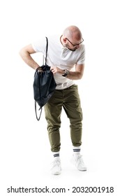 Puzzled Young Bald Shaved Nerdy Man Searching Bag Looking Down For Forgotten Or Lost Item. Full Length Portrait Isolated On White Background