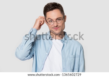 Puzzled young Caucasian man wearing glasses scratch head in confusion thinking of problem, pensive doubtful European male in spectacles isolated on grey studio background look confused or baffled