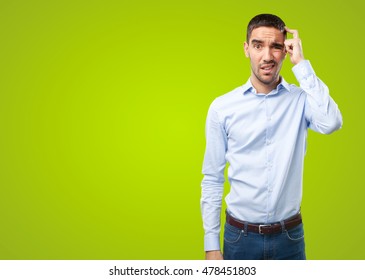 Puzzled Young Man On Green Background