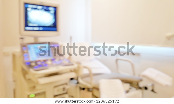 PV : Pelvic, Vaginal examination concept. Blur\
background of medical exam room for Transvaginal or endovaginal\
Ultrasound with hospital bed stirrups and monitor and equipments\
for Obstetrician doctor.