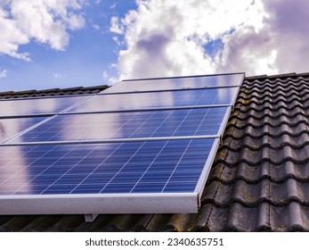 PV system on a house roof with moss and lichen on the tiles - Shutterstock ID 2340635751