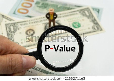 P-Value.Magnifying glass showing the words.Background of banknotes and coins.basic concepts of finance.Business theme.Financial terms.