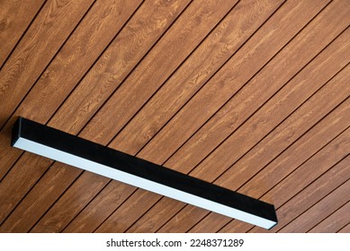 PVC ceiling panel covered with wood-like vinyl with modern lighting installed on it - Shutterstock ID 2248371289