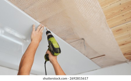 PVC Ceiling Panels, cladding installation indoors. Builder installing, repair white PVC Ceiling Boards in the house bathroom during renovation.