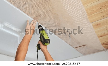 PVC Ceiling Panels, cladding installation indoors. Builder installing, repair white PVC Ceiling Boards in the house bathroom during renovation.