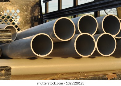 PVC Gray Conduit Pipes In Golden Light On Back Of Work Truck Bed, Close Up.