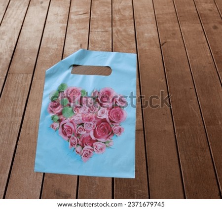 PVC packet of bluish colour with picture of pink roses on it