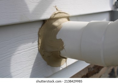 A PVC Radon Vent Pipe Attached to the Side of a Home