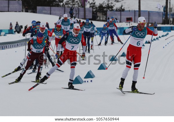 PYEONGCHANG, SOUTH\
KOREA - FEBRUARY 11, 2018: Skiers compete at mass start in the\
Men\'s 15km + 15km Skiathlon at the 2018 Winter Olympic Games at\
Alpensia Cross-Country Skiing\
Centre