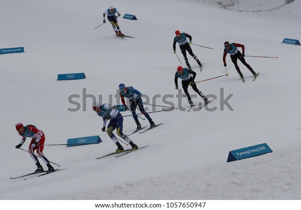 PYEONGCHANG, SOUTH\
KOREA - FEBRUARY 11, 2018: Skiers compete at mass start in the\
Men\'s 15km + 15km Skiathlon at the 2018 Winter Olympic Games at\
Alpensia Cross-Country Skiing\
Centre