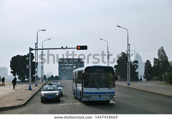 Pyongyang, North Korea - April 30, 2019: Morning\
traffic in Pyongyang. Taxi, bus at the city street at sunrise.\
Local people rush to\
work