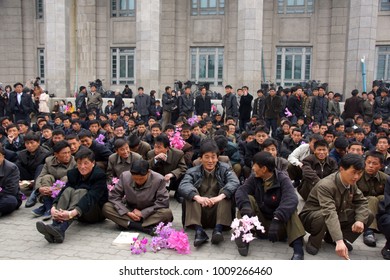 PYONGYANG, NORTH KOREA (DPRK) - APRIL 14, 2012: A Group Of Unidentified Men Wait To Practice Thier Part In The Next Day's Military Parade In Kim Il Sung Square. 