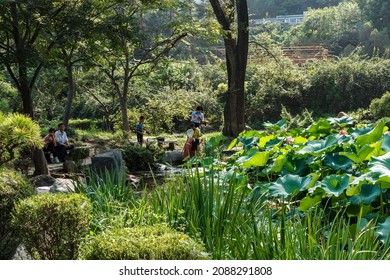 Pyongyang, North Korea - July 27, 2014: Moranbong Park. North Korean People Resting In A Park Near The Lotus Pond.