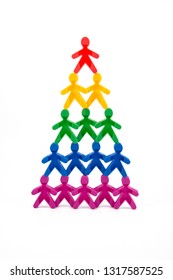 A Pyramid Of Colored Human Figures. Business Concept Idea, Career Ladder, Teamwork. Maslow's Hierarchy Of Needs. On White Background Isolated