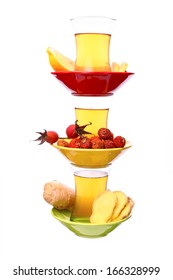 Pyramid of the cup of green tea with lemon, ginger and rosehip, isolated on white background